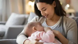 Madre sosteniendo a su bebe con los brazos y dándole la leche materna